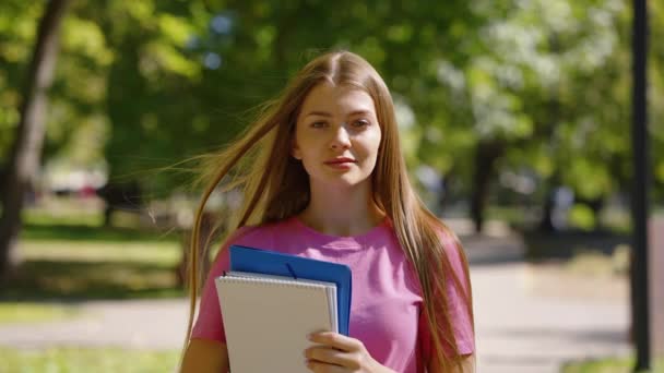 Student v parku s knihami v rukou — Stock video