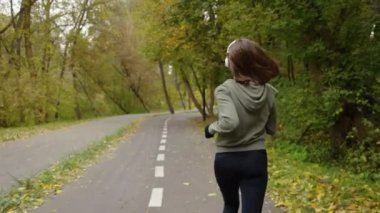 Sonbahar parkında yolda koşan bir kadın