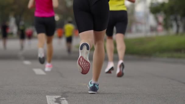 Voeten van marathonlopers op de stadsweg — Stockvideo