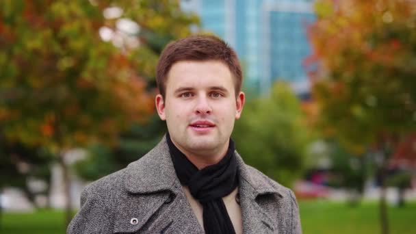 Mężczyzna portret przed jesiennym parkiem — Wideo stockowe