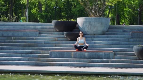 Wanita bermeditasi di yoga berpose di tangga di taman — Stok Video