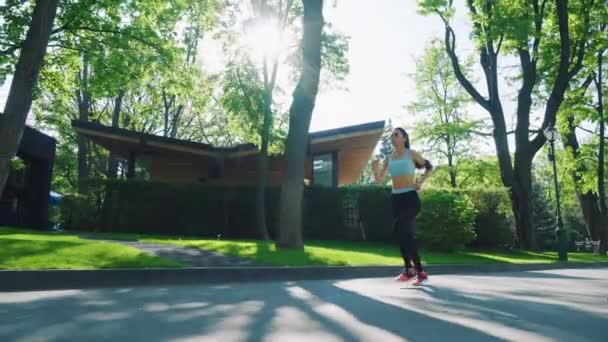 Mujer corriendo bajo el sol brillante en el parque — Vídeos de Stock