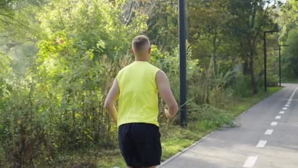 Slow-Motion-Jogger an kühlem Morgen im Park — Stockvideo
