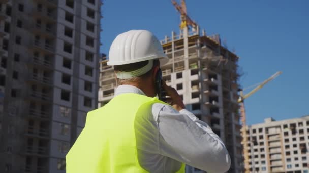 Inspector de construcción haciendo una llamada en el sitio de construcción — Vídeos de Stock