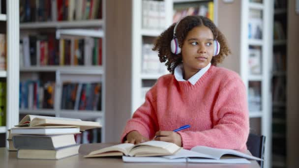 Estudante afro-americana estudando na biblioteca — Vídeo de Stock