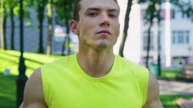 Formda adam yavaş çekimde parkta koşuyor.