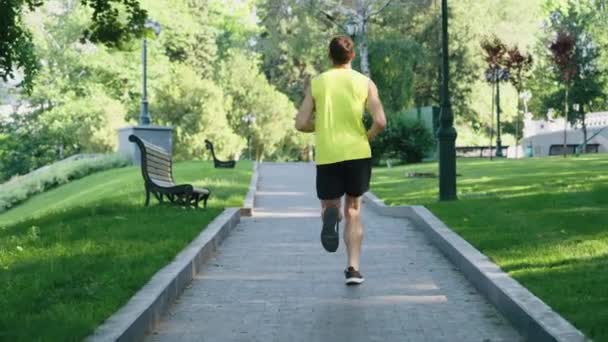 Biegacz biegający w parku letnim w zwolnionym tempie — Wideo stockowe