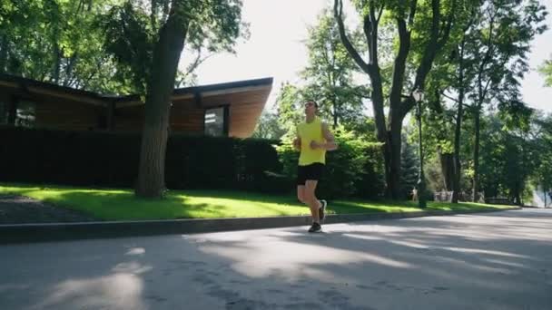 Slow motion jogger körs i sommarparken — Stockvideo