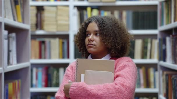 Student som leter etter bøker i biblioteket – stockvideo