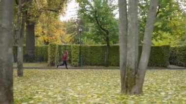 Sonbahar parkında ağır çekimde koşan koşucu