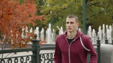 Sonbaharda şehir parkında koşan adam