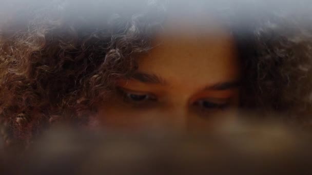 Menina afro-americana lendo títulos de livros na biblioteca — Vídeo de Stock