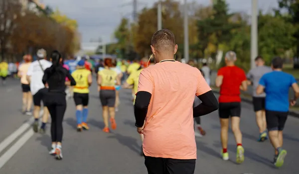 Male runner with earphones at city marathon — Stock Photo, Image