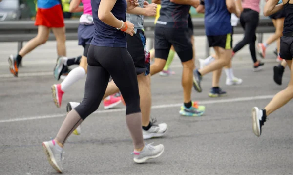 Ноги марафонських бігунів на міській дорозі — стокове фото
