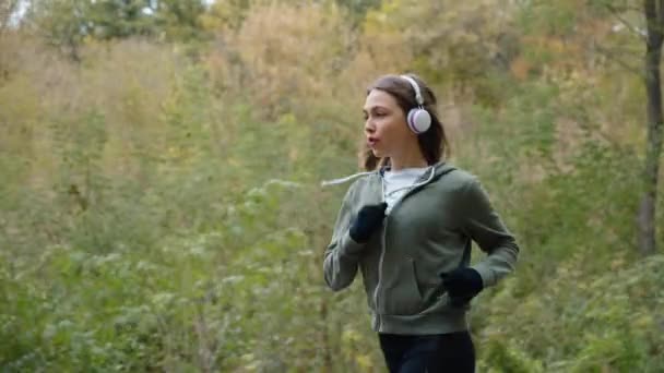 Corredor femenino escuchando audiolibros mientras hace ejercicio — Vídeos de Stock