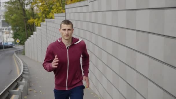 Jogger springer längs väggen i staden — Stockvideo