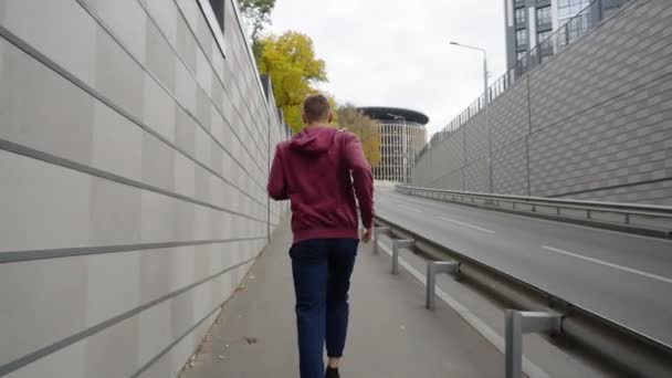Чоловік бігає в місті в повільному русі — стокове відео