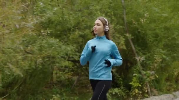 Donna che fa jogging e ascolta audio con le cuffie — Video Stock