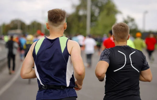 Fit young men running marathon in city — Stock Photo, Image