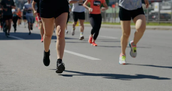 Emberek lábai versenyeznek a maratonon a városban — Stock Fotó