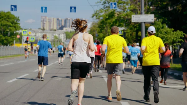 Повільні марафонські бігуни на міській дорозі — стокове фото
