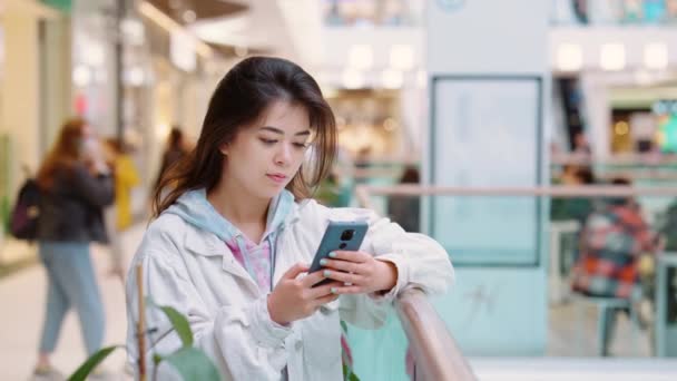 Ασιάτισσα γυναίκα που χρησιμοποιεί smartphone στο εμπορικό κέντρο — Αρχείο Βίντεο