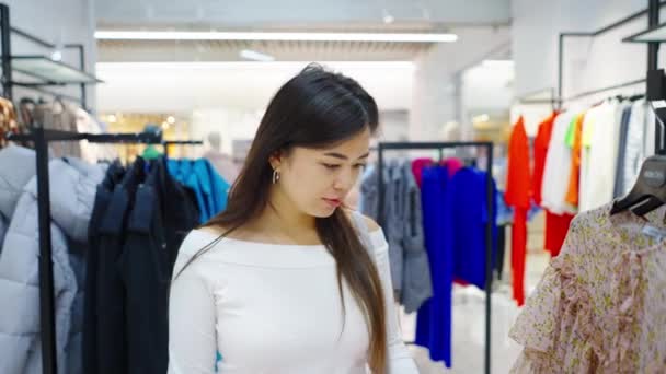 Azji kobieta w sklepie odzieżowym szuka odzieży — Wideo stockowe