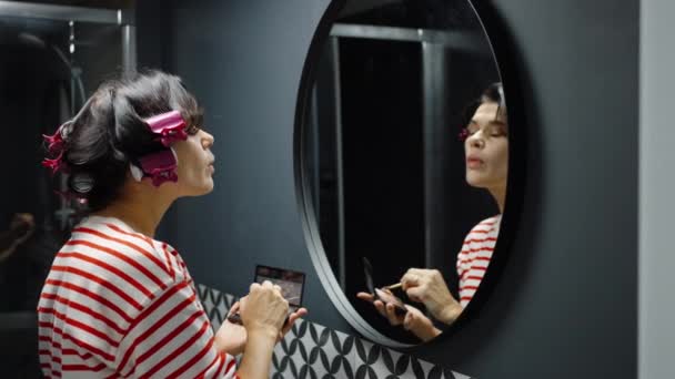 Frau schminkt sich vor Badezimmerspiegel — Stockvideo
