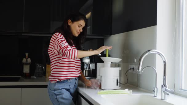 Frau bereitet in Küche Selleriesaft zu — Stockvideo