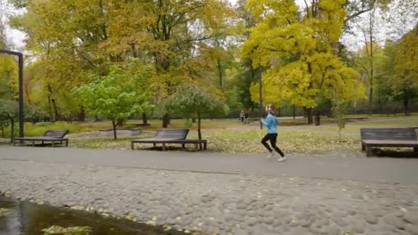 Slow motion kobieta jogging nad rzeką w parku — Wideo stockowe