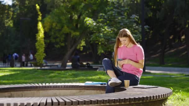 女性在外面的智能手机上浏览社交媒体 — 图库视频影像