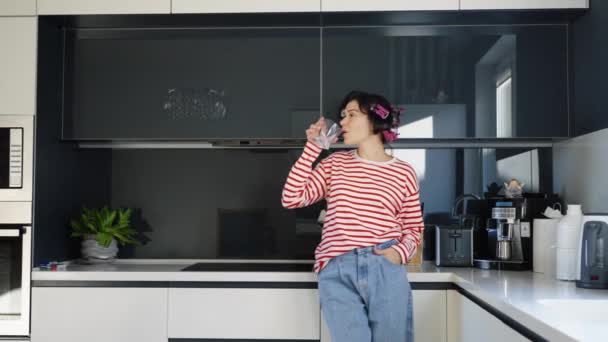 Mujer agua potable en la cocina moderna — Vídeos de Stock
