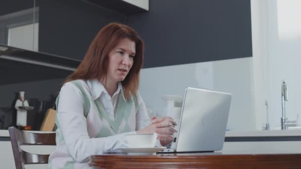 Bizneswoman posiadające spotkanie online na laptopie w kuchni — Wideo stockowe