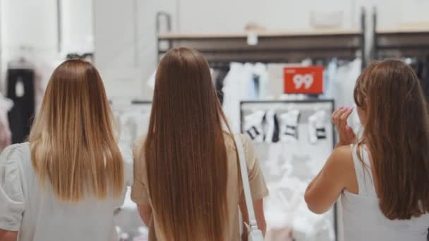 Tres mujeres caminando en la tienda de ropa — Vídeos de Stock