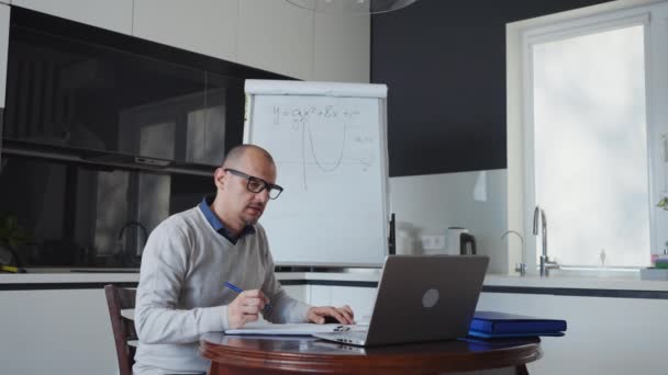 Tutor enseñando desde casa teniendo videoconferencia con los estudiantes en el ordenador portátil — Vídeos de Stock