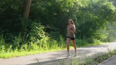 Yavaş hareket eden kadın yazın ormana doğru koşuyor.