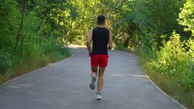 Yavaş çekimde ağaçların arasında koşan bir adam