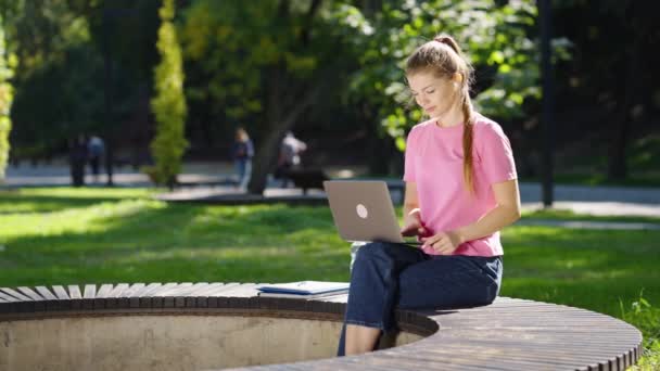 在公园里的笔记本电脑上工作的女人 — 图库视频影像