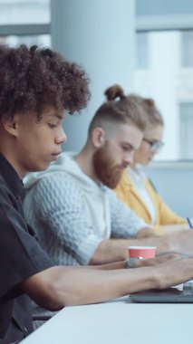 Dikey Ekran: Ofiste dizüstü bilgisayarda çalışan siyah adam