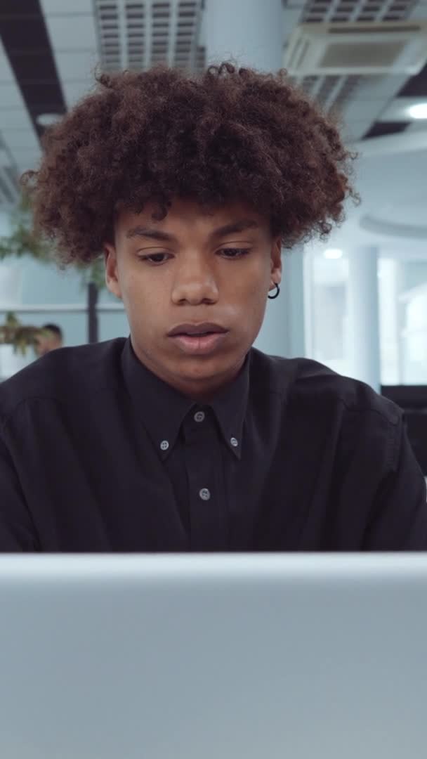 縦型スクリーン:アフリカ系アメリカ人従業員がオフィスのノートパソコンで作業 — ストック動画