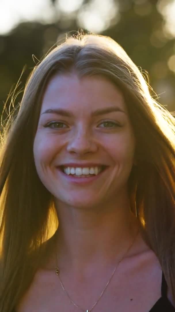 Dikey Ekran: Gülümseyen kadın şehirde gün batımına karşı — Stok video