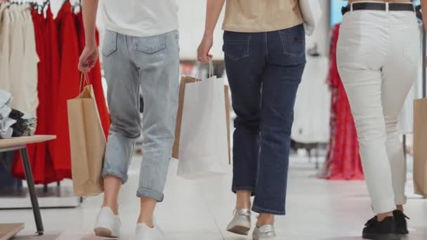 Las nalgas de las mujeres caminando en el centro comercial con bolsas de compras — Vídeos de Stock