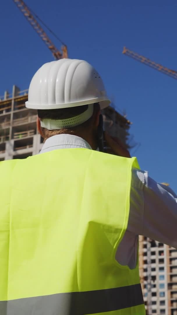 Verticaal scherm: Burgerlijk ingenieur inspecteert bouwplaats — Stockvideo