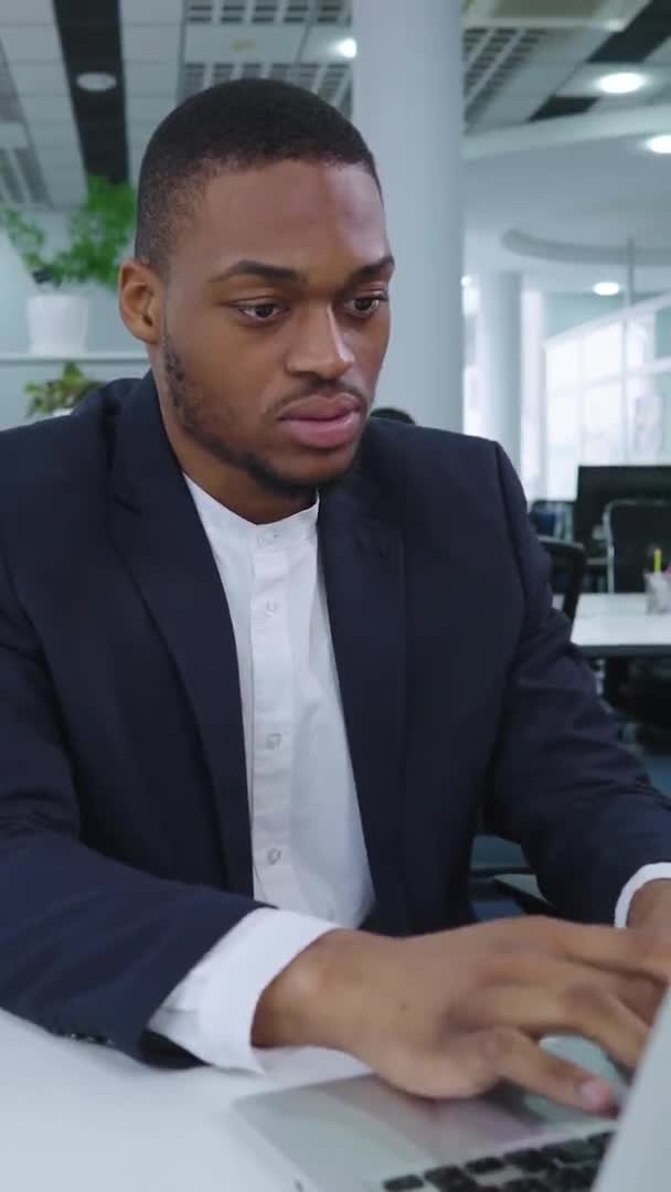 Écran vertical : Homme d'affaires noir utilisant un ordinateur portable dans l'espace de coworking — Video