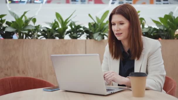 Bizneswoman o konferencji online na laptopie w kawiarni — Wideo stockowe