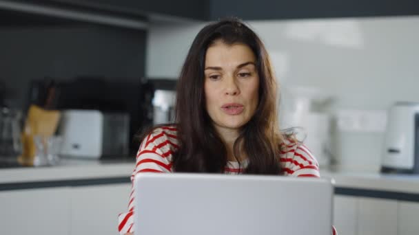 Женщина в чате онлайн на ноутбуке дома — стоковое видео