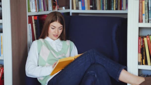 Mujer leyendo best seller libro en la biblioteca — Vídeos de Stock