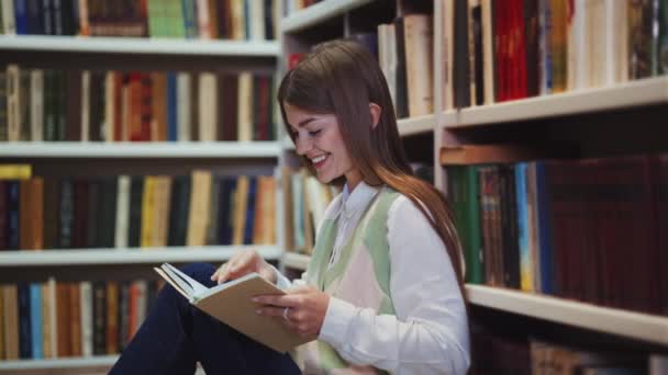 Студент читает книгу на библиотечном этаже — стоковое видео