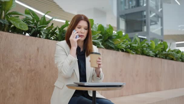 コーヒーブレイクで電話で話すビジネスマンの女性 — ストック動画