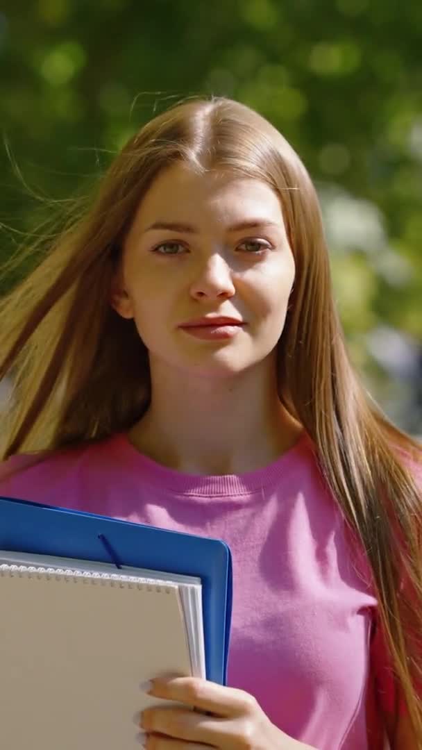 Dikey Ekran: Parktaki öğrenci elinde kitaplarla — Stok video